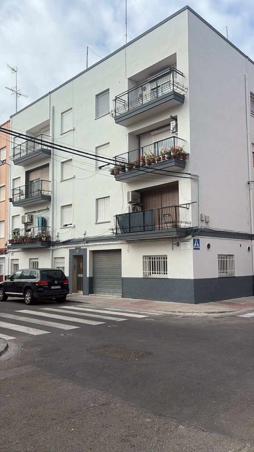 Fachada de edificio rehabilitado en esquina con balcones y pintura exterior renovada